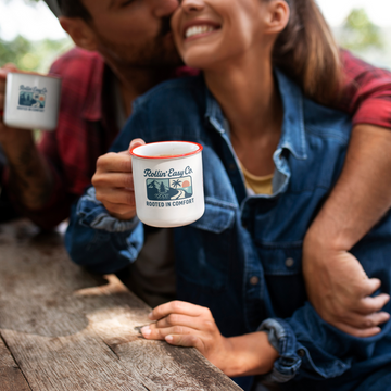 Person holding a mug with a scenic design outdoors